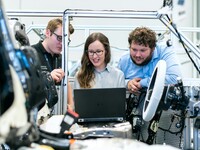 Three engineers looking at computer