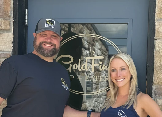 Owners of the GoldFinch Tap standing in front of their business' door