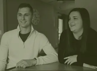 A man and woman sitting at a table smiling