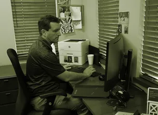 A man sitting at his desk on the computer