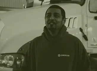 A man smiling, wearing a CementTech hoodie