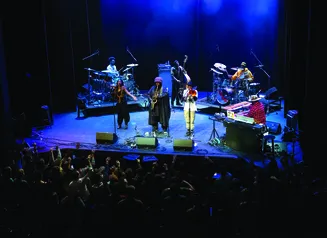 Musicians performing on stage with blue lighting