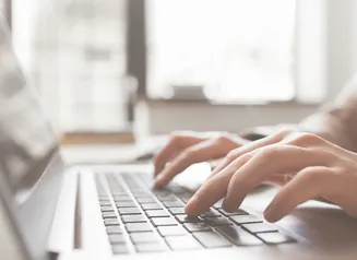 Fingers typing on laptop keyboard