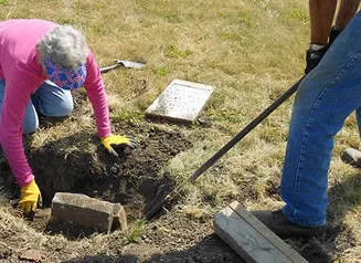 People working on restoring an old grave site