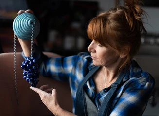 Glass artist holding her work