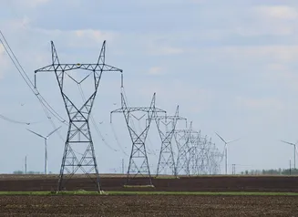 Transmission towers and wind turbines on a field