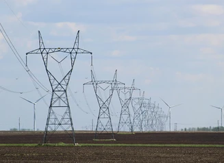 Transmission towers and wind turbines on a field