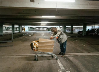 Unhoused person with shopping cart in an urban setting