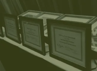 Awards from Office of the Governor displayed on a table