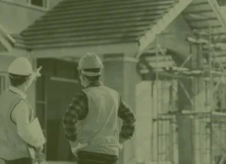 Two construction workers looking at house
