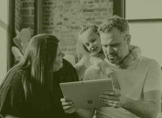 Mom, dad, and daughter looking at laptop