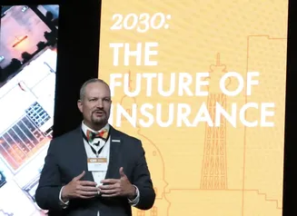 Jason Gross in front of a screen that reads 2030: The Future of Insurance