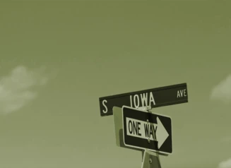 One Way street sign underneath S Iowa Ave sign