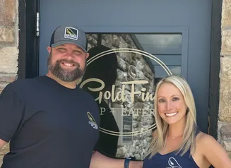 Owners of the GoldFinch Tap standing in front of their business' door
