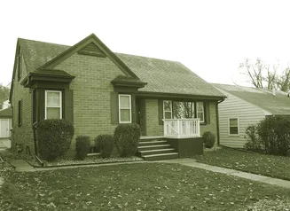 Brick story and half home with sidewalk