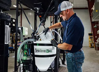 Man in hat wearing gloves and mixing product in a container that reads PROVEN 40