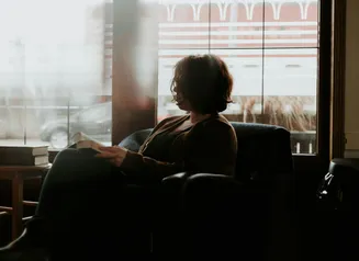 Woman reading a book in comfy chair