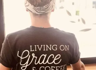 The back of a tee shirt reading Living on Grace & Coffee