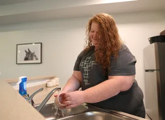 Woman washing dishes at a sink