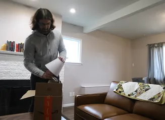 Man unpacking a lamp from a cardboard box