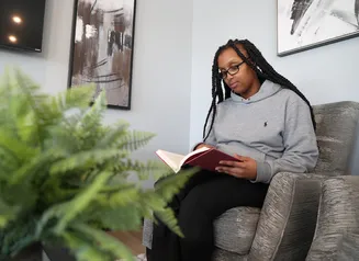 woman reading a book in her home