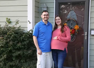 a couple standing by their front door