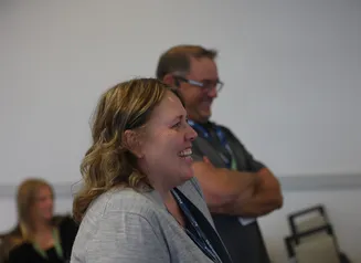 A woman wearing gray is smiling
