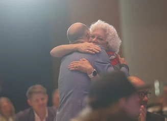 two people hugging at an awards ceremony
