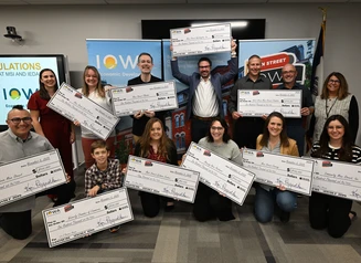 award recipients holding giant checks