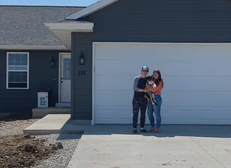 Family standing in front of house.