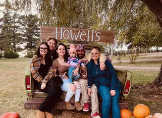 Family sitting on haystack