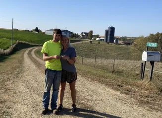 Two people standing side by side on gravel road
