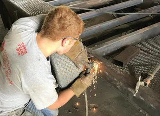 Farmer doing welding on equipment.