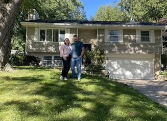 Couple standing in front of house