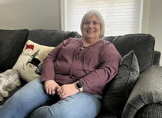 Woman sitting on couch.