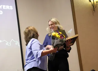 Presenting award and flowers to recepient