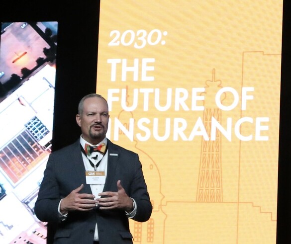 Jason Gross in front of a screen that reads 2030: The Future of Insurance