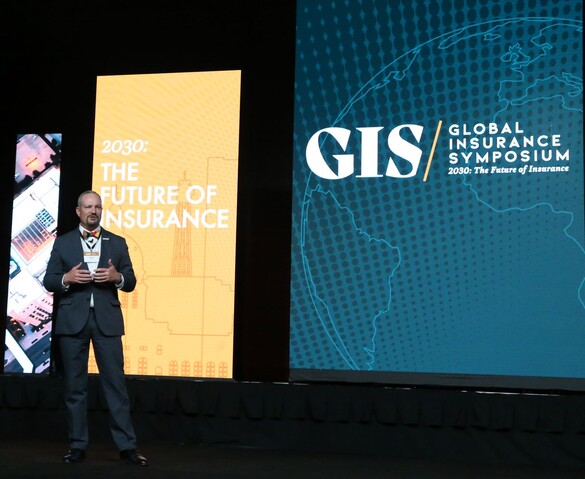Jason Gross in front of a screen that reads 2030: The Future of Insurance taken at the Global Insurance Symposium event
