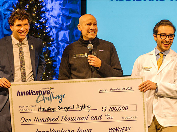 Representatives from Hawkeye Surgical Lighting holding an oversized check for $100,000 from the InnoVenture Challenge