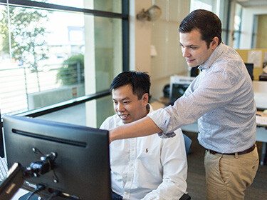 Karsten Temme, CEO, with Pivot Bio co-founder Alvin Tamsir looking at a computer screen
