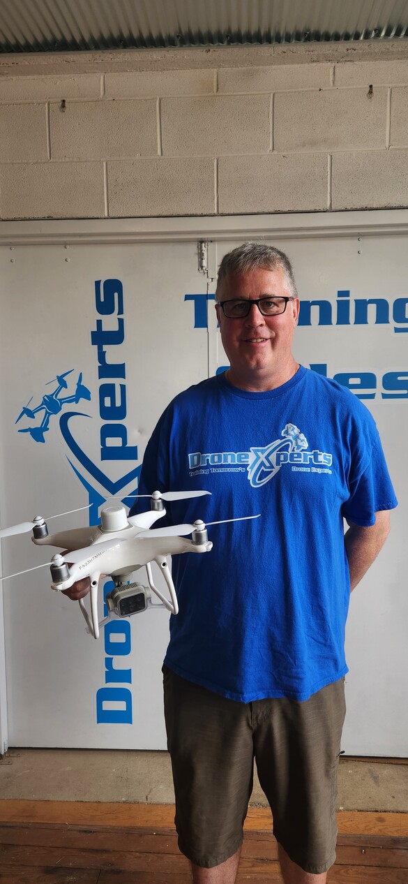 Owner of DroneXperts holding a white drone