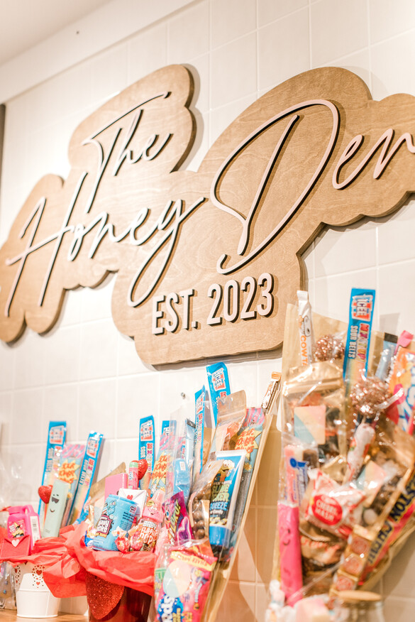 Wall sign that reads The Honey Den est. 2023