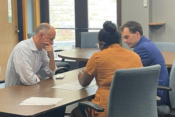 three people working together in a conference room