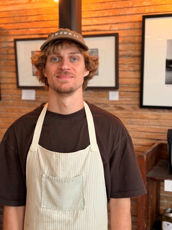 headshot of a man wearing a hat and an apron