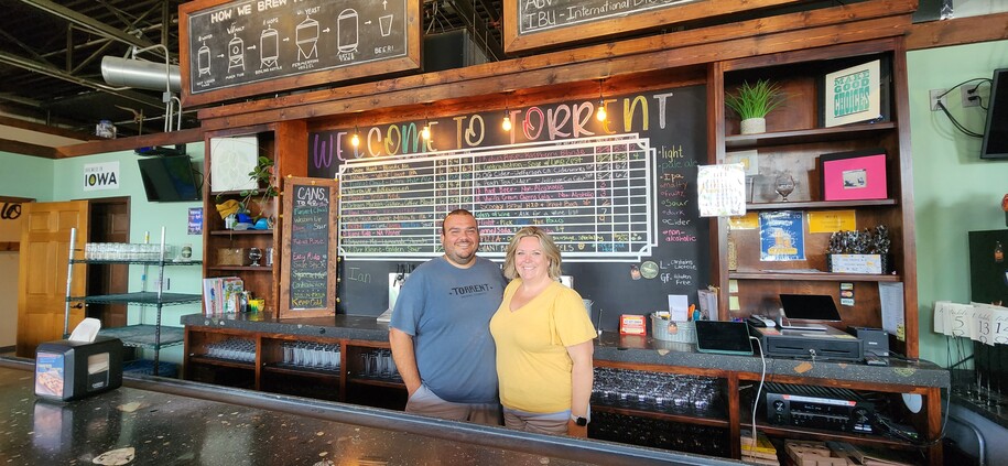 the owners of torrent brewing company standing behind the bar