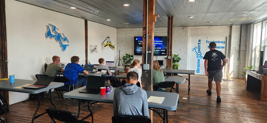 Class of students sitting at tables at DroneXperts