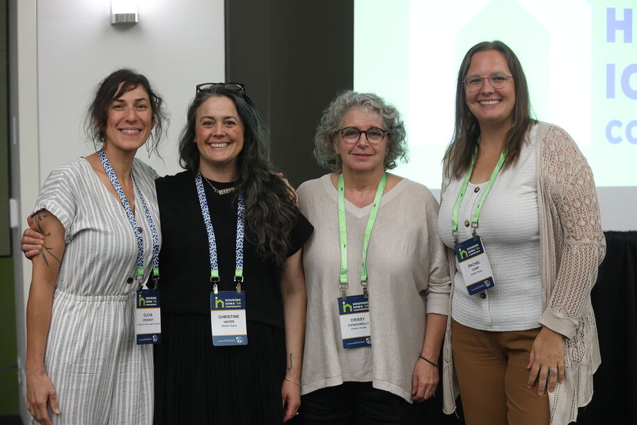 four people posing together at a conference